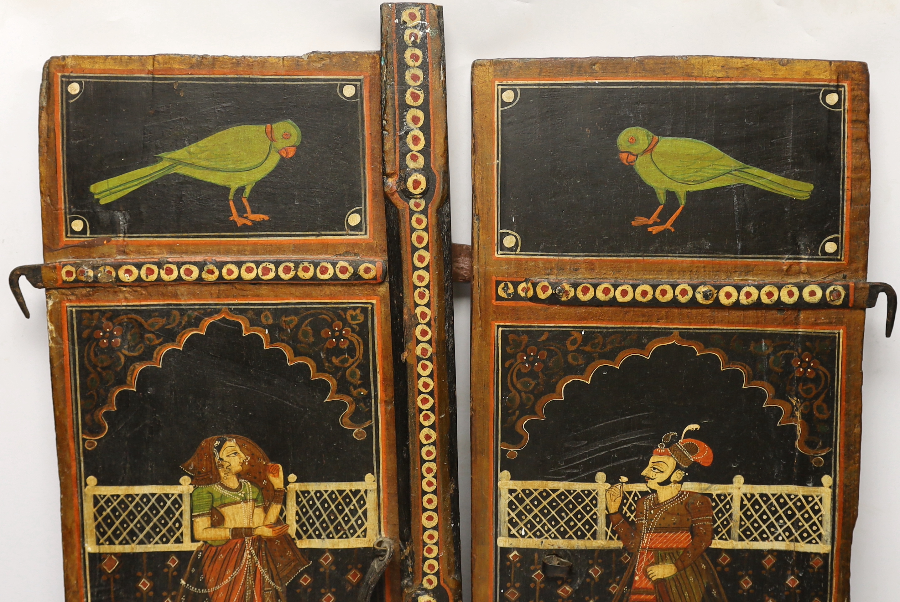 A pair of painted Indian shutters hand painted with figures and birds, 67cm high